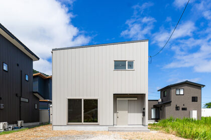 青空に映える白銀色の外観のお家